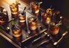 Essential Whiskey Cocktails Every Man Should Know How to Order Classic whiskey cocktails arranged on bar with traditional garnishes and tools